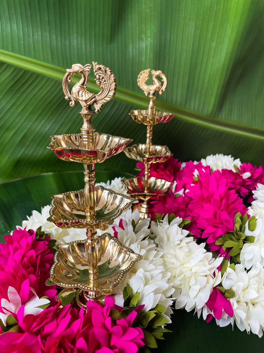 Decorative brass lamp with flowers on a green leaf background