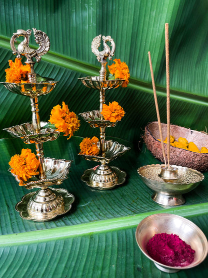 Decorative silver lamps with marigold flowers on a green leaf background
